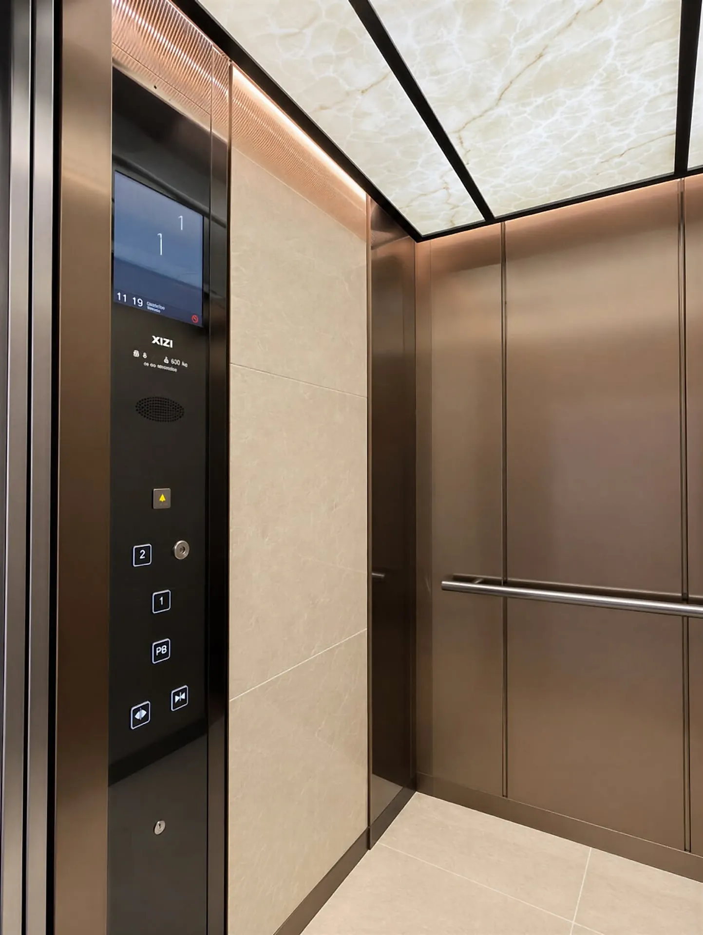 Cabina de elevador vista en ángulo, con plafón luminoso y botonera con pantalla